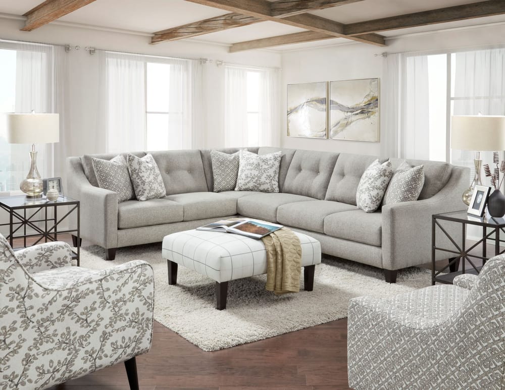 A bright living room with a neutral sectional and accent chairs